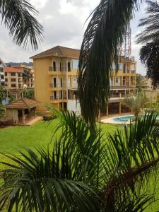 坎帕拉的住宿－Spacious 3 Bedroom Apartment Excellent Location Bugolobi Kampala - Immersion 1，享有带游泳池和棕榈树的度假村的景致