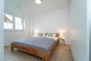 1 dormitorio con 1 cama y 2 ventanas en Ostseelaune, en Scharbeutz