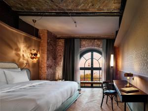 a bedroom with a bed and a desk and a window at Telegraphenamt in Berlin +193 photos