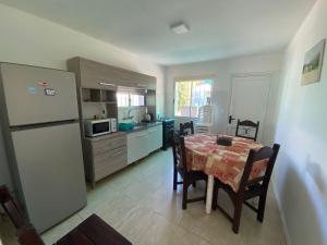 a kitchen with a dining table and a refrigerator at Philadelphia3 dormitorios in Punta del Este