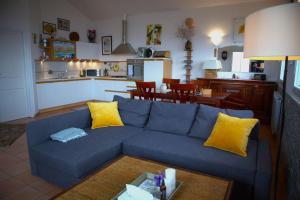a living room with a blue couch and a kitchen at Chalet Perinaldo in Perinaldo