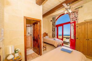 a bedroom with two beds and a view of the ocean at Ta Kristoff Holiday Home in Qala