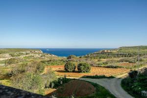 a road in a field with the ocean in the background at Ta Kristoff Holiday Home in Qala