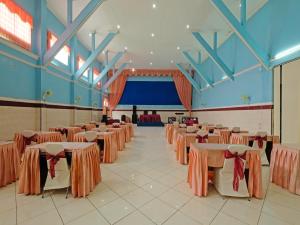 un salón de banquetes con mesas, sillas y un escenario en Collection O 91914 Hotel Citra Dewi 2 Int's, en Semarang