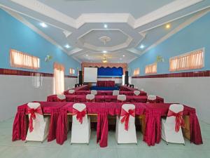 un salón de banquetes con mesas rojas y sillas blancas en Collection O 91914 Hotel Citra Dewi 2 Int's, en Semarang