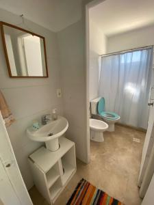 a bathroom with a sink and a toilet and a mirror at Philadelphia3 dormitorios in Punta del Este