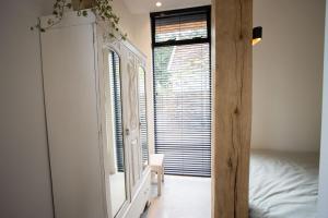 um quarto com um espelho, uma cama e uma janela em Natural Green Loft em Bergen