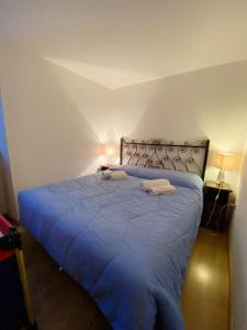 um quarto com uma cama azul com duas almofadas em Appartamento con 3 camere da letto in Centro Courmayeur em Courmayeur