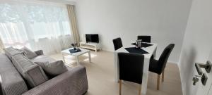 a living room with a couch and a table with chairs at Apartament 4 Piętro in Kołobrzeg