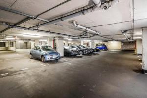 un garage avec plusieurs voitures qui y sont garées dans l'établissement 2-Bed Apartment Near Basildon Train Station, à Basildon