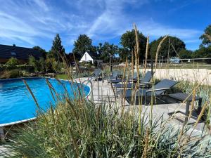 a swimming pool with lounge chairs next to a yard at Ulinia Zacisze Dom Comfort 70m2 in Ulinia