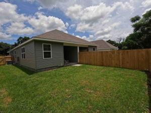 a house with a fence in a yard at The Aymara Boutique Spacious New Construction DWTN in Pensacola