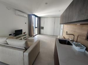 ein Wohnzimmer mit einem Sofa und einem Waschbecken in einem Zimmer in der Unterkunft Apartamentos Las Pasaeras in Montehermoso