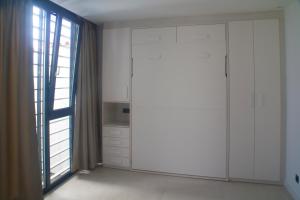 eine Küche mit weißen Schränken und einem großen Fenster in der Unterkunft Apartamentos Las Pasaeras in Montehermoso
