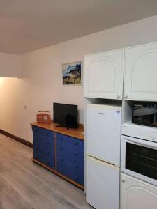a kitchen with white appliances and a desk with a television at Murray's Lodge: Self-Catering Accommodation. in Cavan