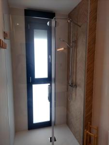 ein Bad mit einer Dusche und einem Fenster in der Unterkunft Apartamentos Las Pasaeras in Montehermoso
