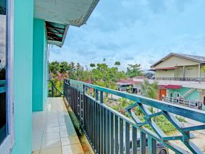 a balcony of a house with a blue railing at SPOT ON 91918 Najla Guest House Syariah in Parit