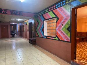un couloir orné d'une fresque murale colorée. dans l'établissement Hostal Choja, à Quetzaltenango