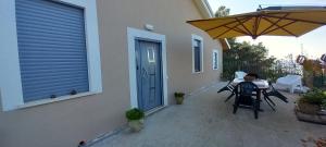 a person sitting at a table under an umbrella on a patio at La Custarella Di Paestum in Capaccio-Paestum