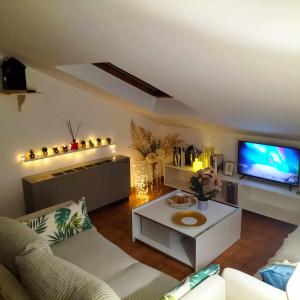 a living room with a couch and a tv at Milordo Gubbio Apartment in Gubbio