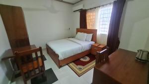 a small bedroom with a bed and a window at Bassi Hotel in Takoradi