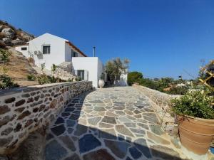 a stone walkway leading to a white building at Villa Simantiri in Pómbia
