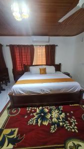 a bedroom with a large bed with a red rug at Bassi Hotel in Sekondi-Takoradi