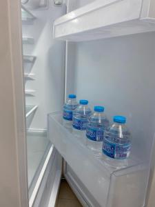 cuatro botellas de agua sentadas en un refrigerador abierto en Casa del Mar a la Sierra, en Setenil