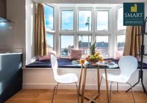 a kitchen with a table and white chairs and a window at King's House by Smart Apartments in Southampton