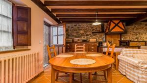 a dining room with a table and a kitchen at Casa rural con encanto en Potes by Alterhome in Potes