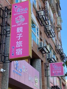 羅東鎮的住宿－童玩樂親子旅宿Toy Fun Hotel，建筑物一侧的粉红色标志