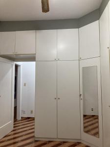 um armário branco com armários brancos num quarto em Espaço Copacabana Comfort Two Bedrooms - Alugue o apartamento inteiro no Rio de Janeiro