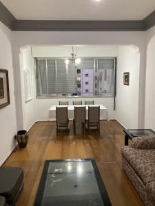 sala de estar con mesa, sillas y sofá en Espaço Copacabana Comfort Two Bedrooms - Alugue o apartamento inteiro, en Río de Janeiro