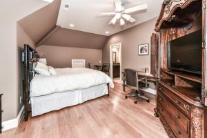 a bedroom with a bed and a flat screen tv at The Manor at Courtland Farm in Aldie