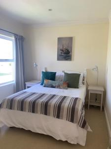 1 dormitorio con 1 cama con manta a rayas en River Club Vacation Home en Plettenberg Bay