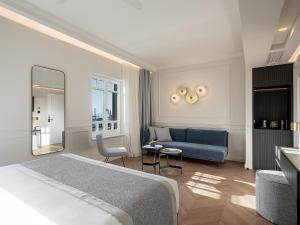 Habitación de hotel con cama y sofá en Riviera Suites en La Canea