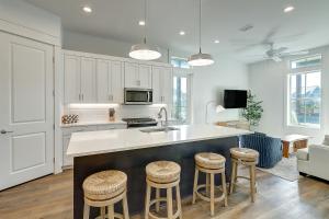 a kitchen with a sink and bar stools at Beaches and Bunkers in Port Aransas