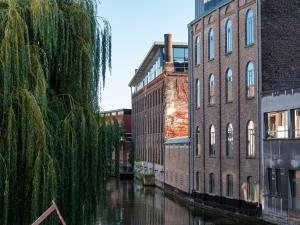 un canal en una ciudad con edificios y un río en Ghent River Hotel en Gante