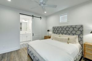 a white bedroom with a bed and a ceiling fan at Beaches and Bunkers in Port Aransas