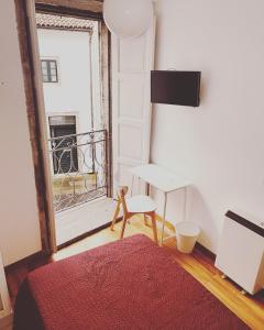 a room with a bed and a table and a window at Hostal San Pelayo in Santiago de Compostela