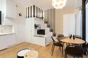 uma sala de estar com mesa e cadeiras e uma cozinha em Stunning 1BR 6 Sleeps Apt Saint Germain-Luxembourg em Paris