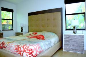 a bedroom with a bed with a red bird on it at Beautiful and relaxing villa near the Beach! in Naples