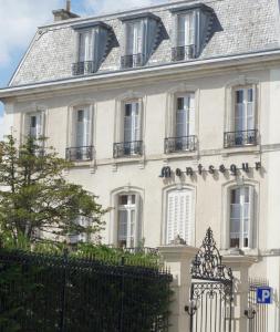 una casa bianca con una recinzione di fronte di Hotel Montsegur a Carcassonne