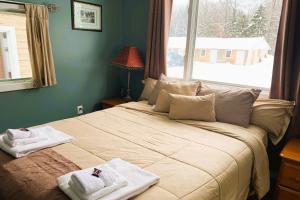 um quarto com uma cama grande e toalhas em Love Hotels St John River at Fort Kent ME em Saint John