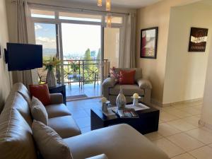 un soggiorno con divano e tavolo di Beautiful apartment, Terrace with incredible view, 3 bdr, Escalon, Exclusive, Secure a San Salvador