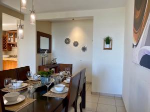 a dining room with a table with chairs and glasses at Beautiful apartment, Terrace with incredible view, 3 bdr, Escalon, Exclusive, Secure in San Salvador +36 photos
