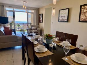 a dining room with a table and chairs and a couch at Beautiful apartment, Terrace with incredible view, 3 bdr, Escalon, Exclusive, Secure in San Salvador