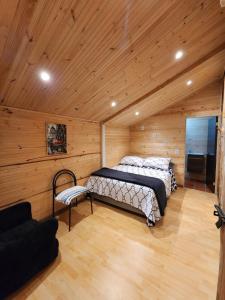1 dormitorio con 2 camas en una habitación de madera en La chala Guatavita, en Guatavita