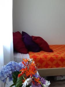 een bed met kleurrijke kussens en bloemen erop bij Casa del Cerro San Javier in Yerba Buena