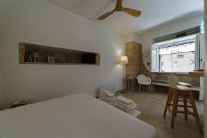 um quarto com uma cama, uma secretária e uma janela em Apartment Don Giuliano Centro em Lecce